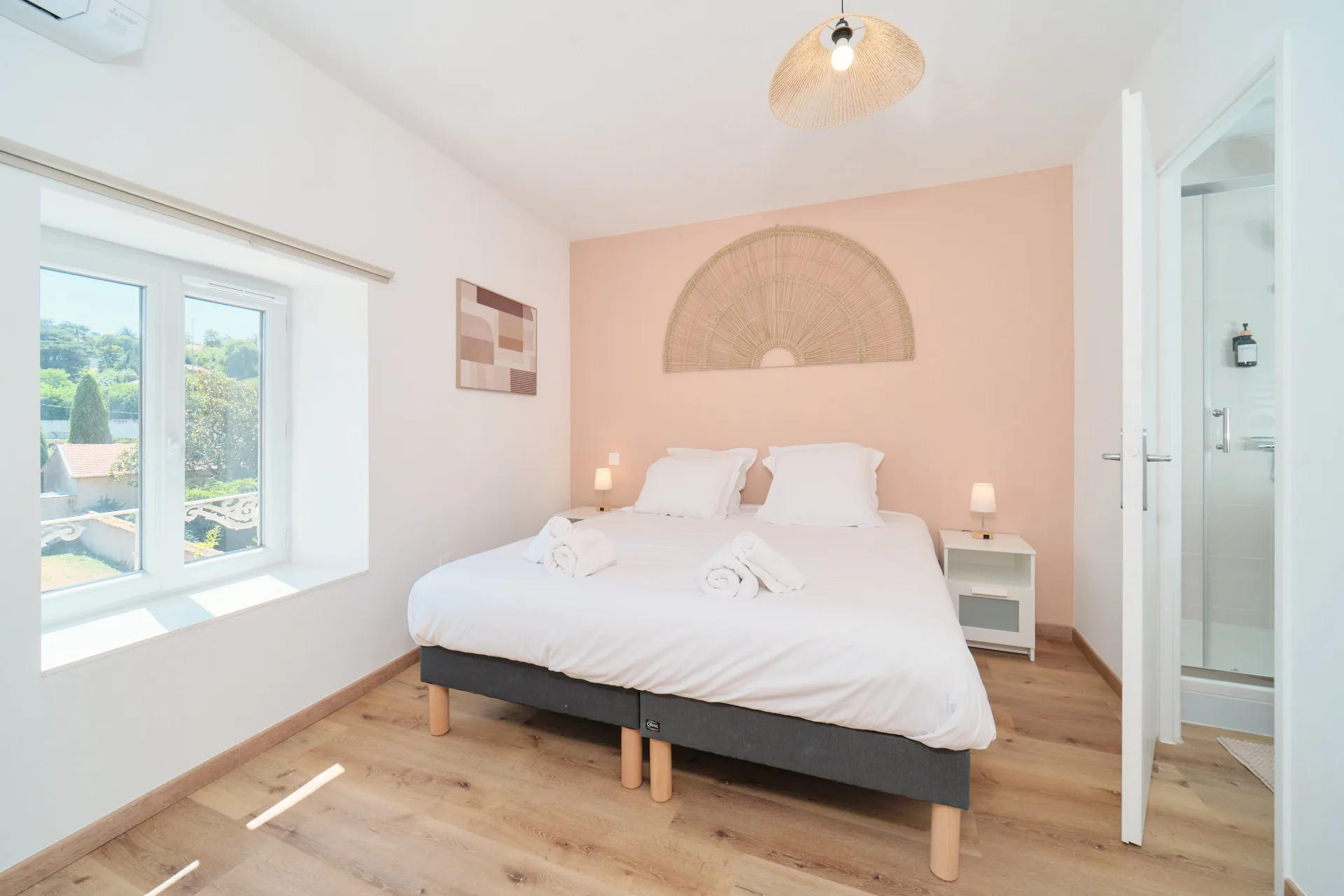 Chambre double donnant sur le jardin, avec grand lit, douche privative et lumière naturelle.